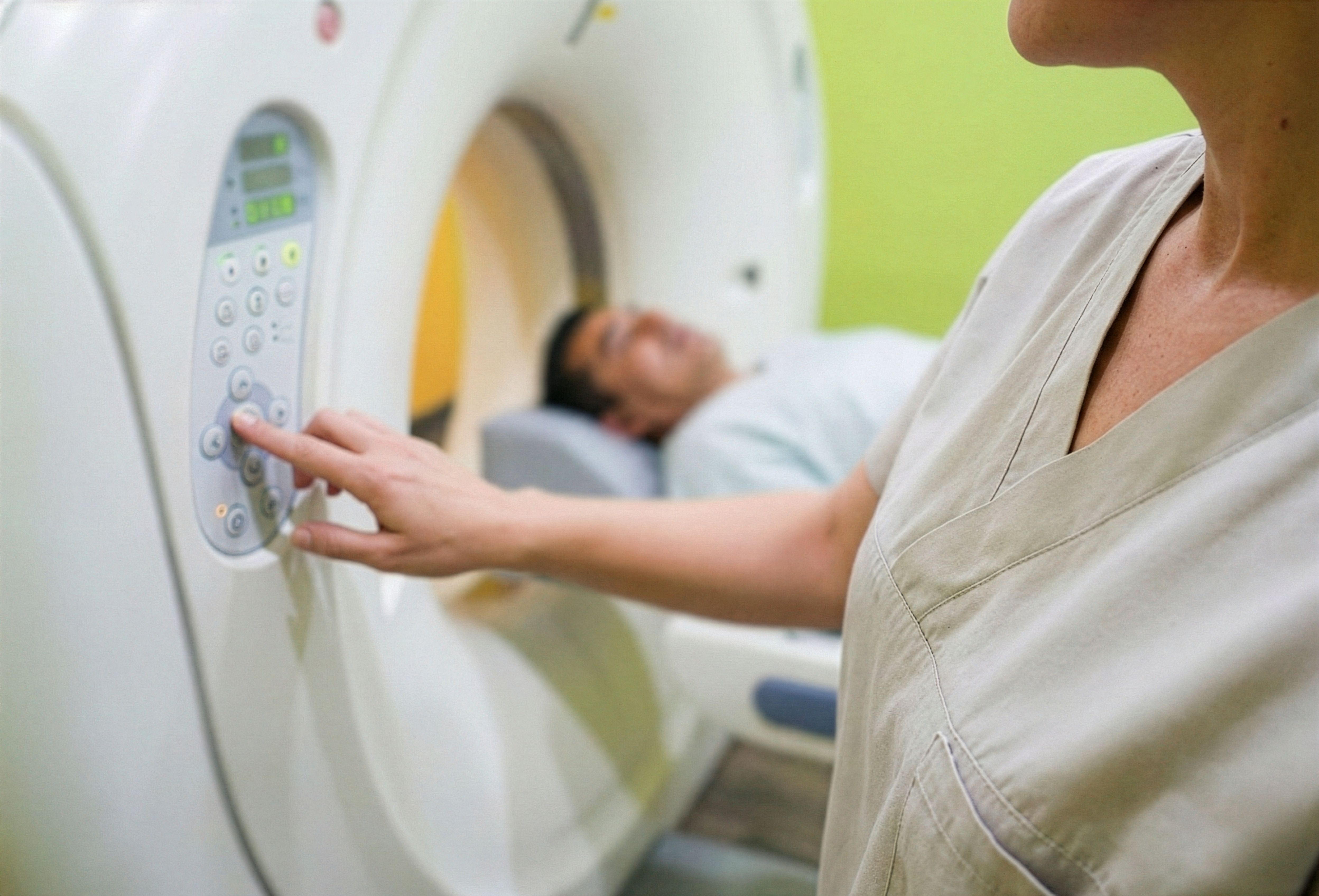 Tecnica de imagenologia operando el panel de control del tomografo